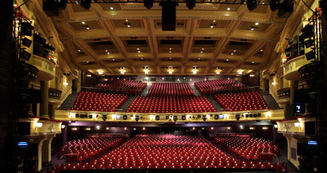 The interior of Birmingham Hippodrome's auditorium. A very large theatre with red seats.